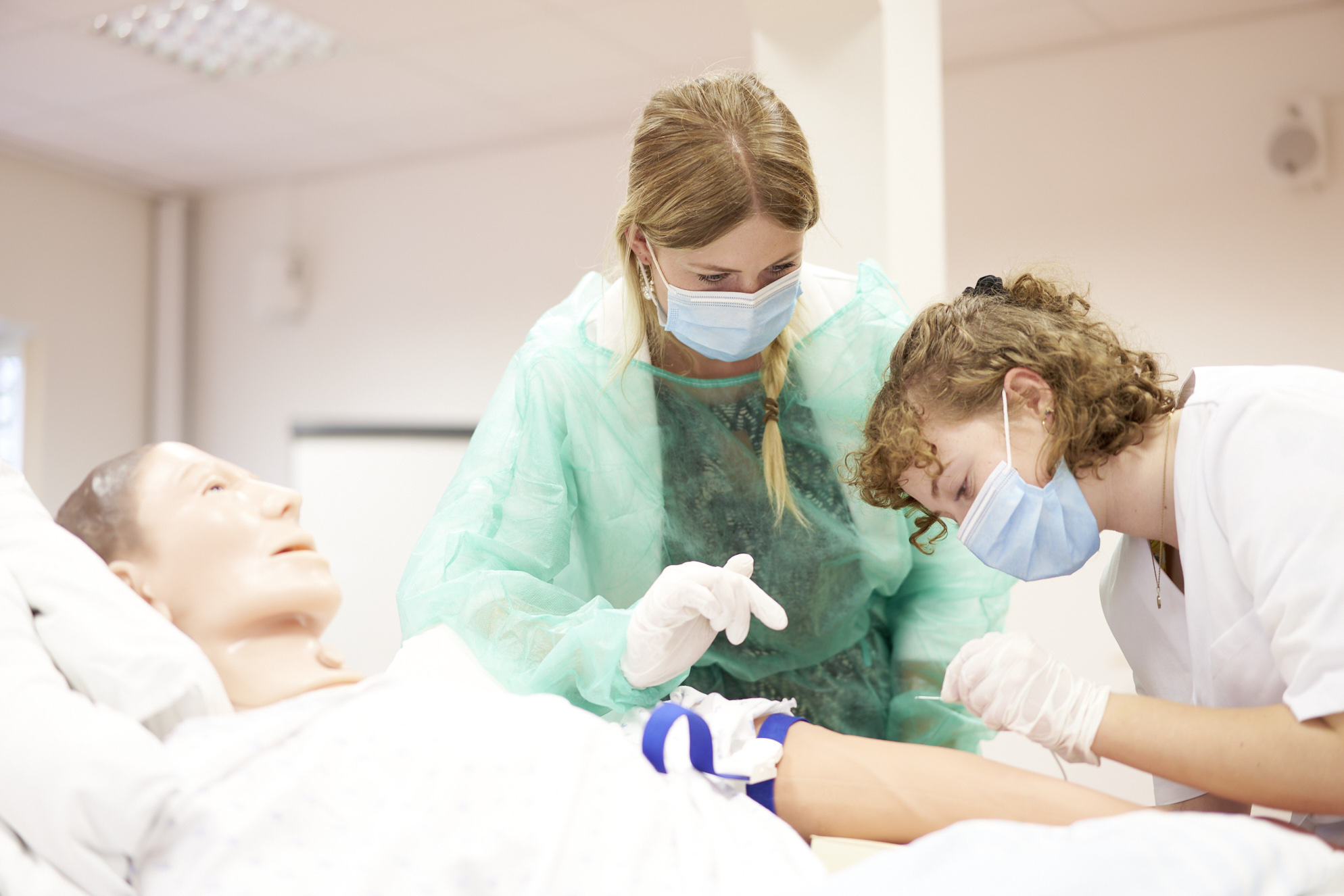 Im Praxisraum des Akademiegebäudes leitet eine Ärzte, eine Pflegerin an, wie sie einem Patienten Blut abnimmt. (Bild: LWL/Haslauer)