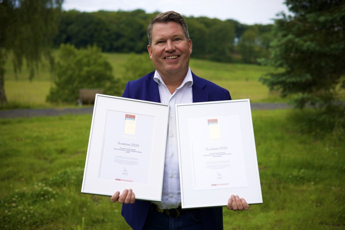 Dr. Patrick Debbelt zeigt seine beiden eingerahmten Siegel.